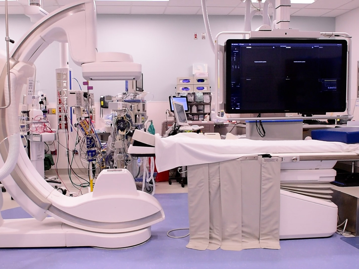 Emergency equipment in a room with an x-ray machine and surgical table.