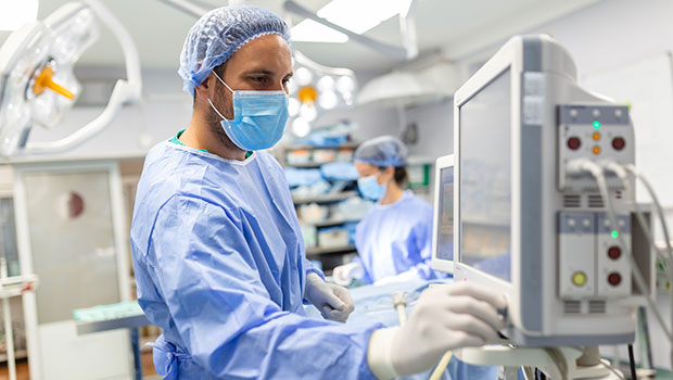 Surgeon adjusts monitor in operating room