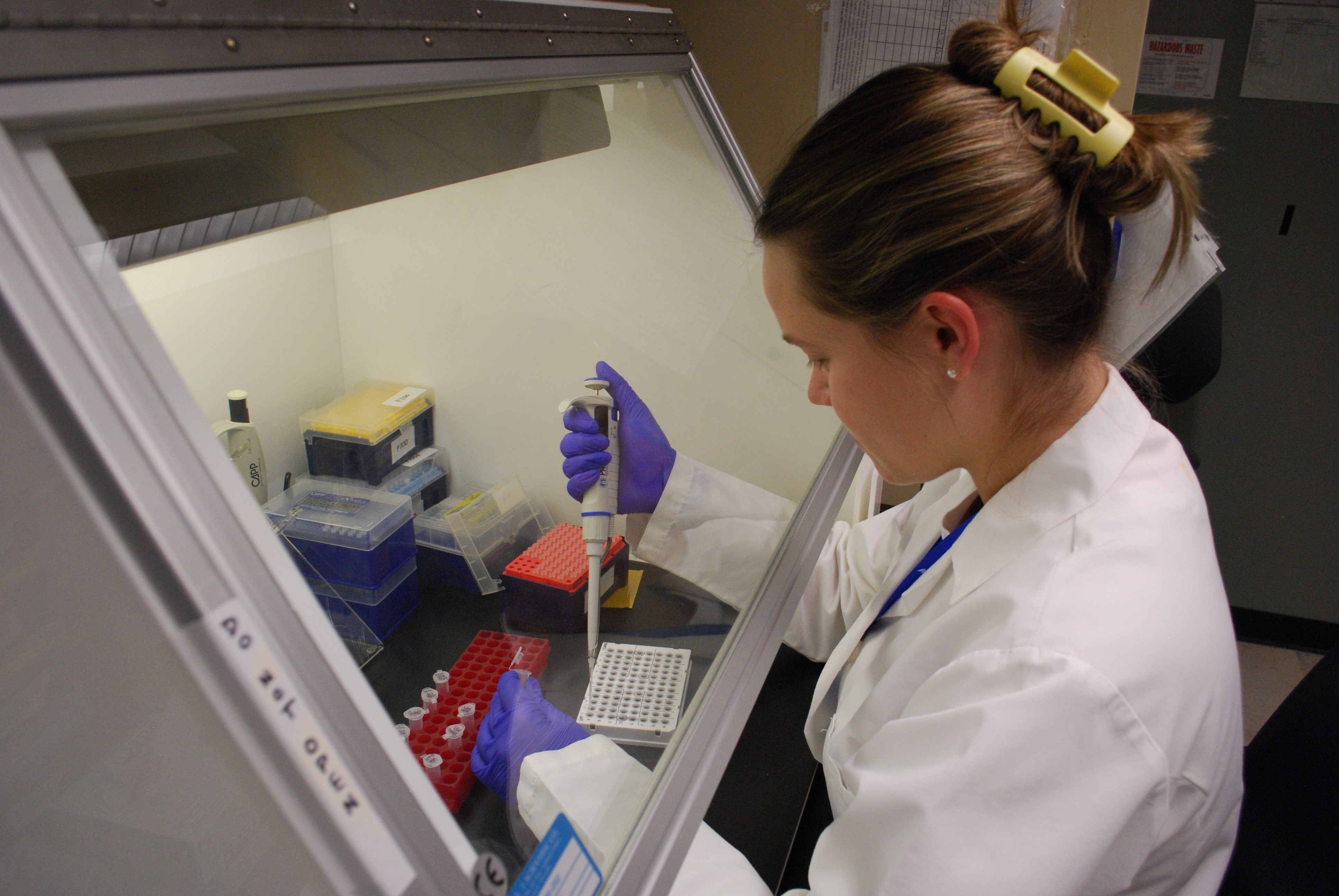 A woman in a lab coat works on PCR