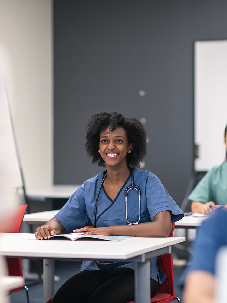 Smiling resident sitting at a desk