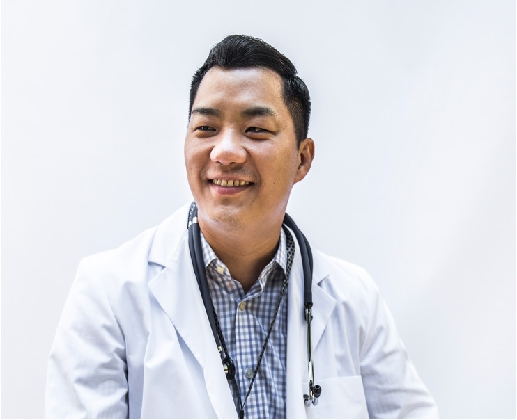 Resident in white lab coat smiling