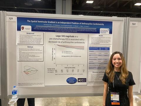 Woman standing in front of a board with a poster on it.