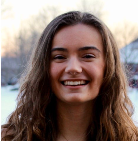Woman with long brown hair smiling at camera.