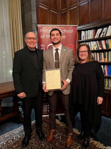 Sarnoff Fellow Frank Medina holds Gold Humanist aware plaque and stands with parents