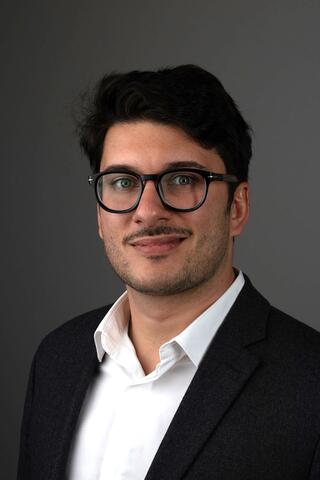 Photo of Dr. Maxime Lebaz wearing glasses and a suit