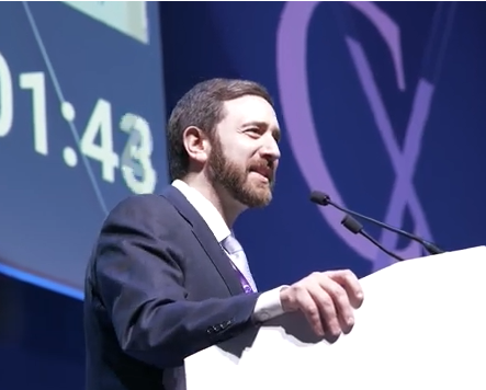Photo of Dr. Secemsky at the podium presenting his lecture at CX 2026