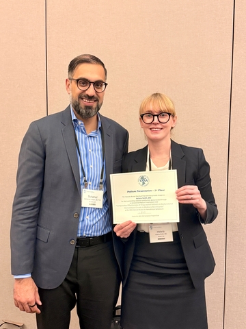 Dr. Helena Smith stands beside mentor Dr. Mohamad Hussain and holds up certificate of award for Top Abstract at VASA 2026