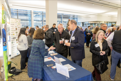 People attend an information fair at a convention center.