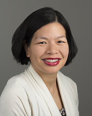 Woman with short black hair and red lipstick smiles at the camera