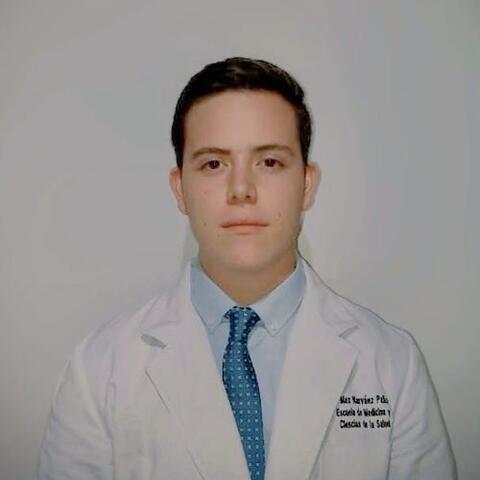 Max in a white lab coat in front of a white background.