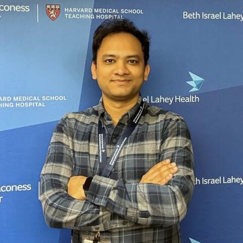 Moydul in a plaid shirt smiling