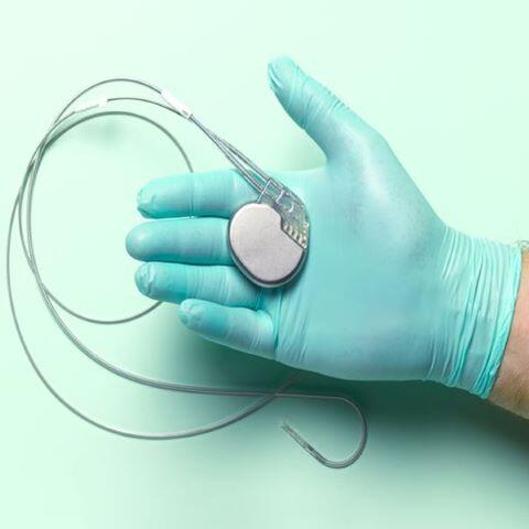 Pacemaker device held by gloved hand