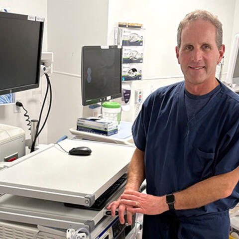 Hypertension Clinic patient stands by blood pressure monitor