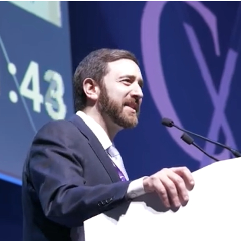 Photo of Dr. Secemsky at the podium presenting his lecture at CX 2026