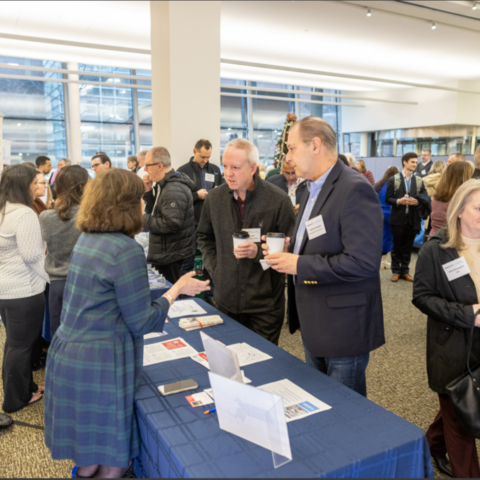 People attend an information fair at a convention center.