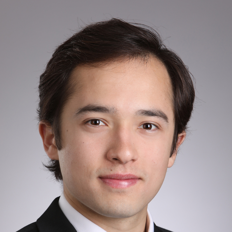 Headshot of a smiling young man in a business suit