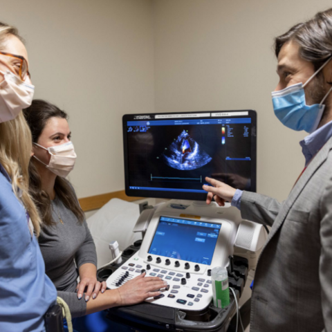 Dr. Strom and two sonographers looking at an echo machine