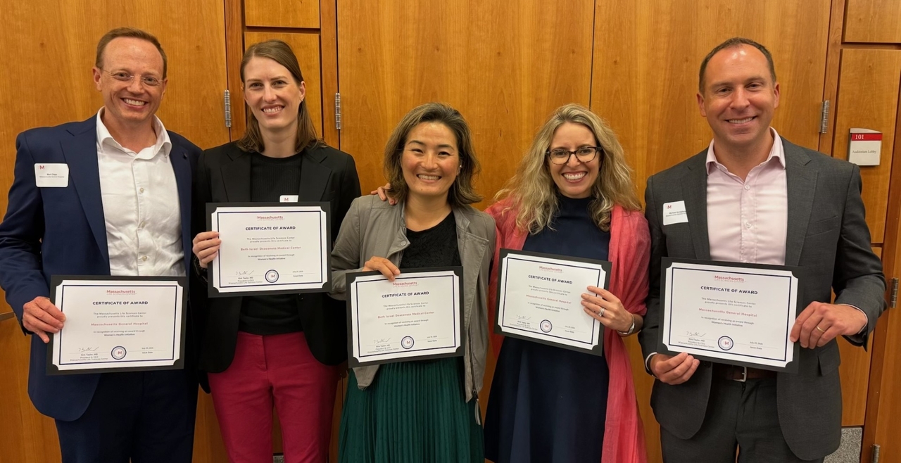 Dr. Ai-ris Collier and colleagues holding awards