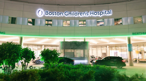 Boston Children's Hospital sign above entrance with cars parked