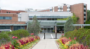 Exterior of Beverly Hospital with a large lawn and flower bed
