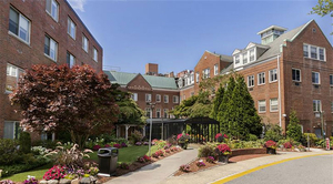 A walkway lined with flowers and plants leads to Winchester Hospital.