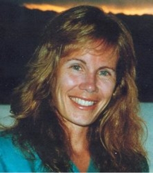 Blonde woman, Katherine Swan Ginsburg, with brown eyes and a big smile wearing a blue shirt