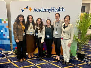 Six women stand behind a wall with the AcademyHealth logo.