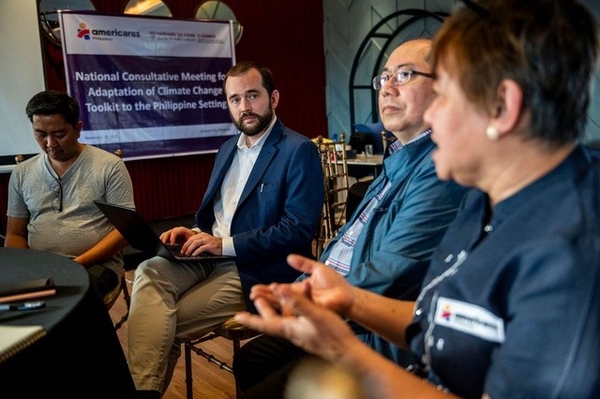 Caleb Dresser sitting and speaking with others at a workshop