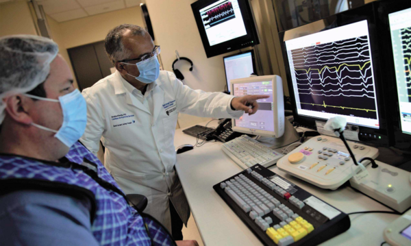 Two doctors looking at a monitor with a graph.