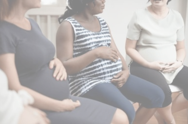 Three pregnant women sitting in chairs, hands on their bellies.